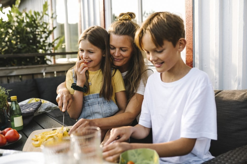 En mor og barn som sitter ute og spiser
