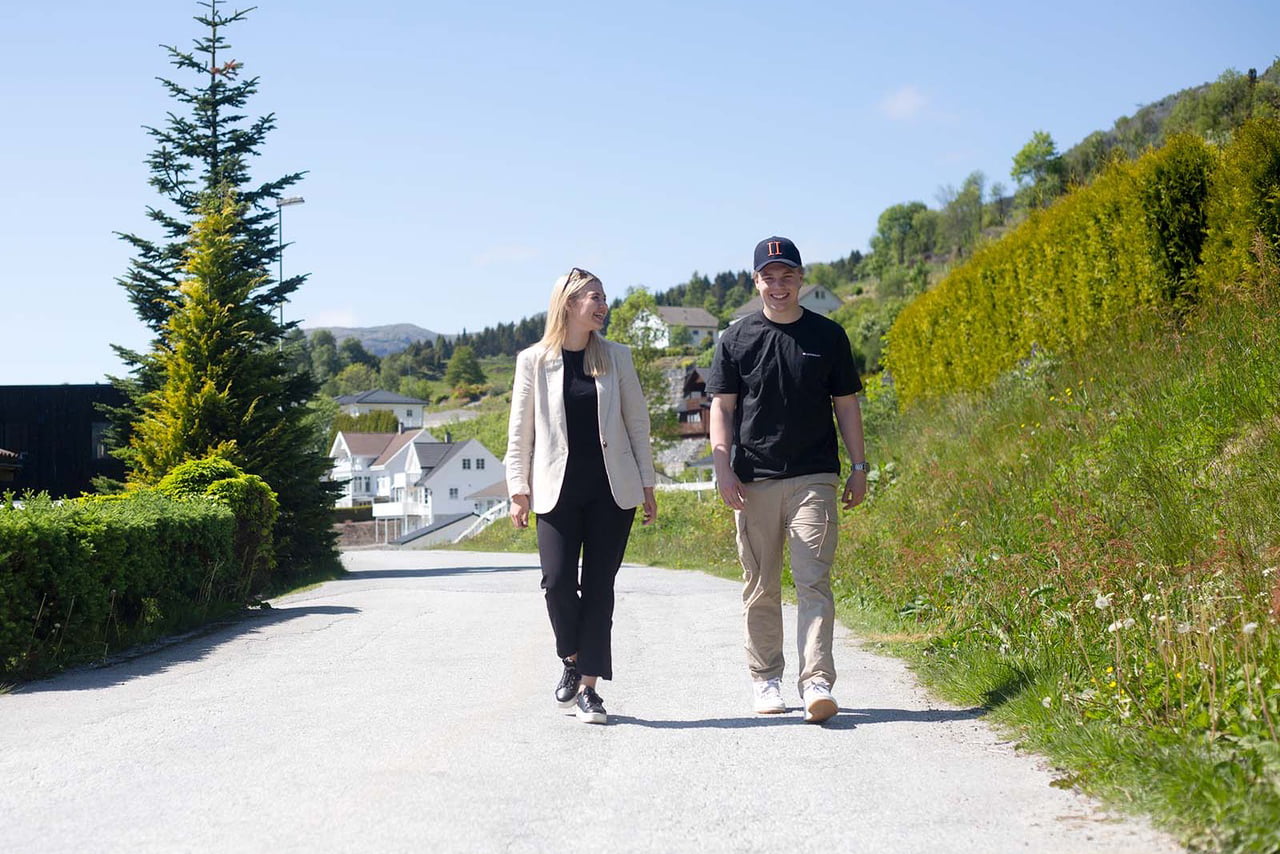 Ung mann i caps går på vei sammen med ung kvinne 