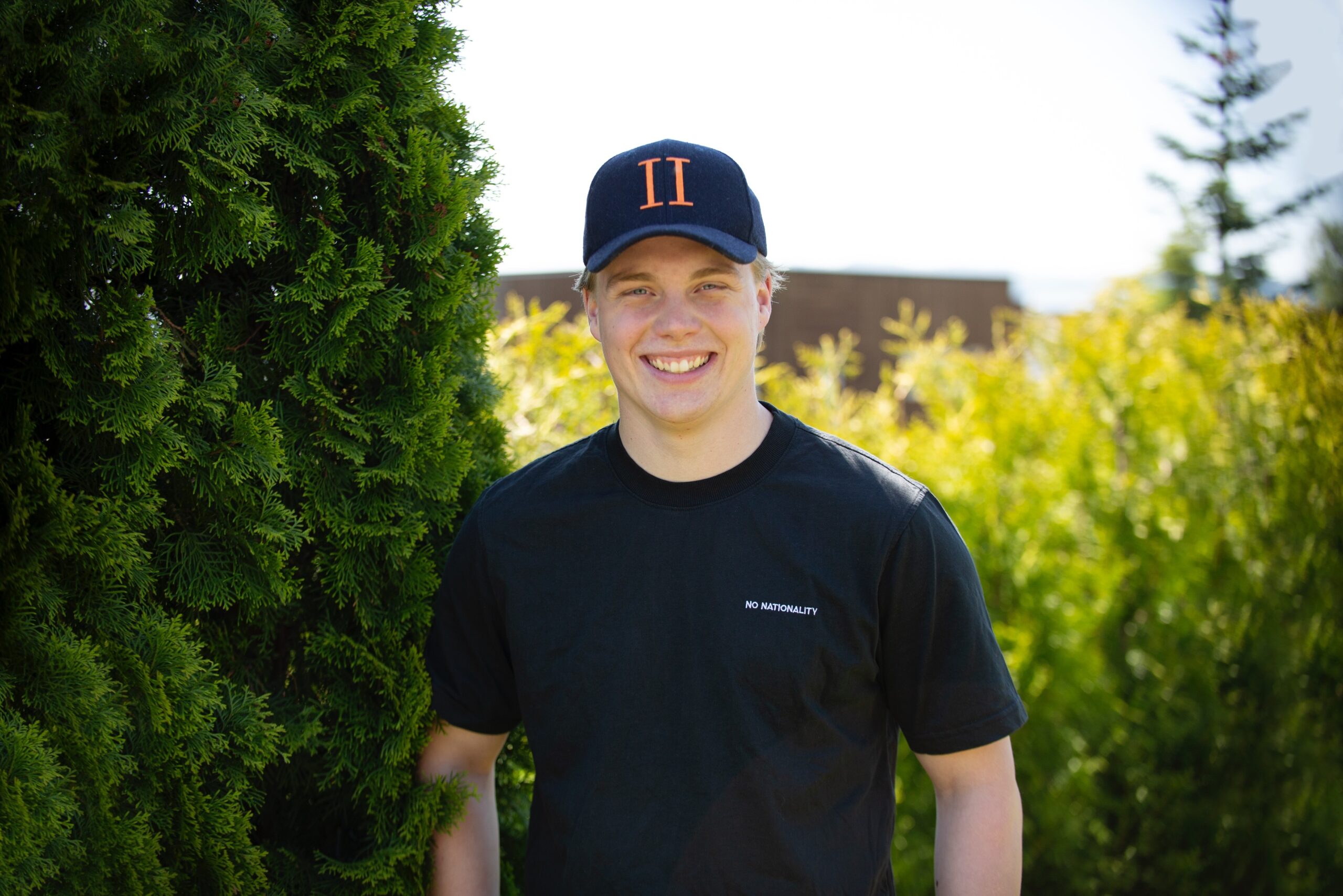 Ung mann i caps står i hage