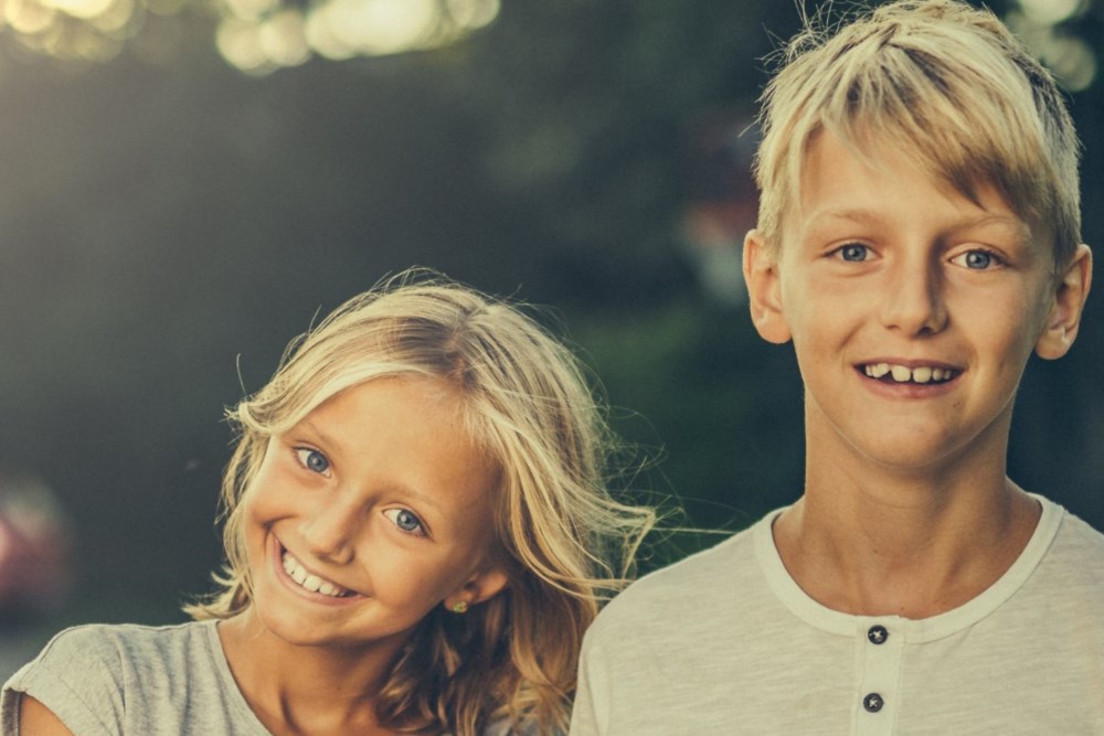 En ung jente og gutt smiler