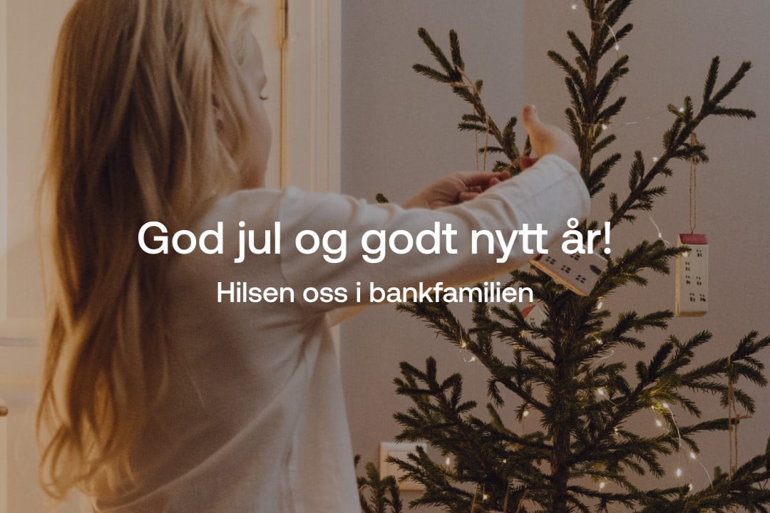 En jente henger opp julepynt på et juletre. Ordene: God jul og godt nytt år! Hilsen oss i bankfamilien