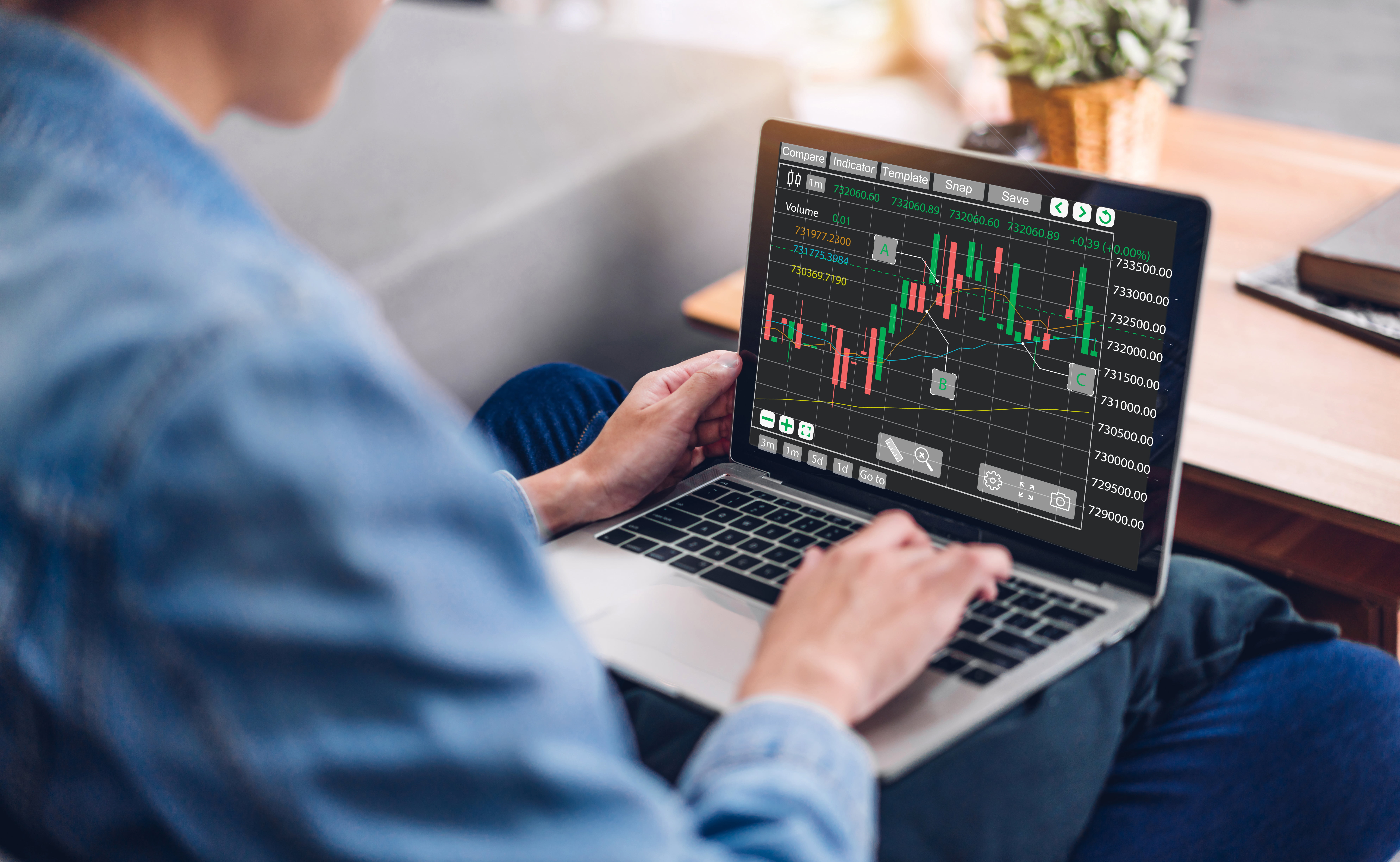 En mann ser på en laptop som viser aksjeutvikling